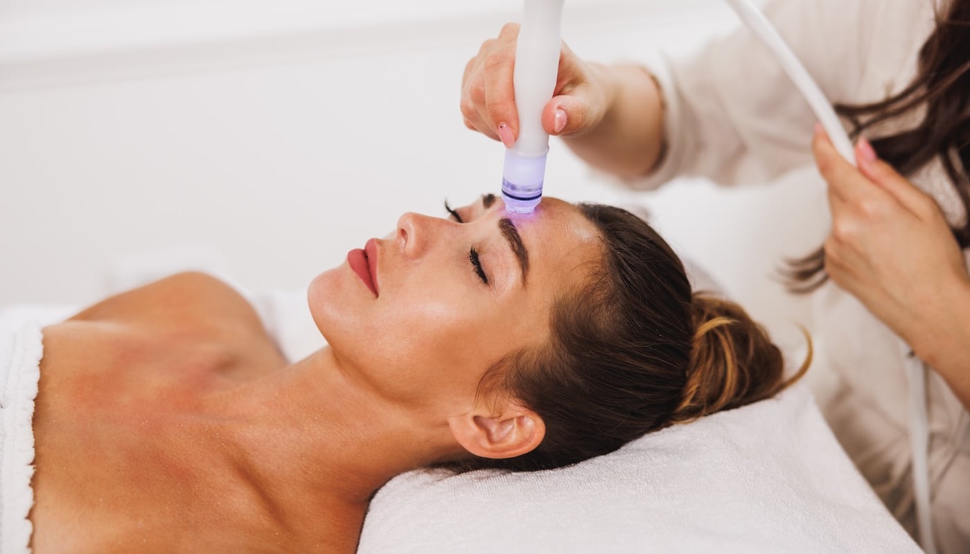 woman receiving facial treatment woman receiving facial treatment